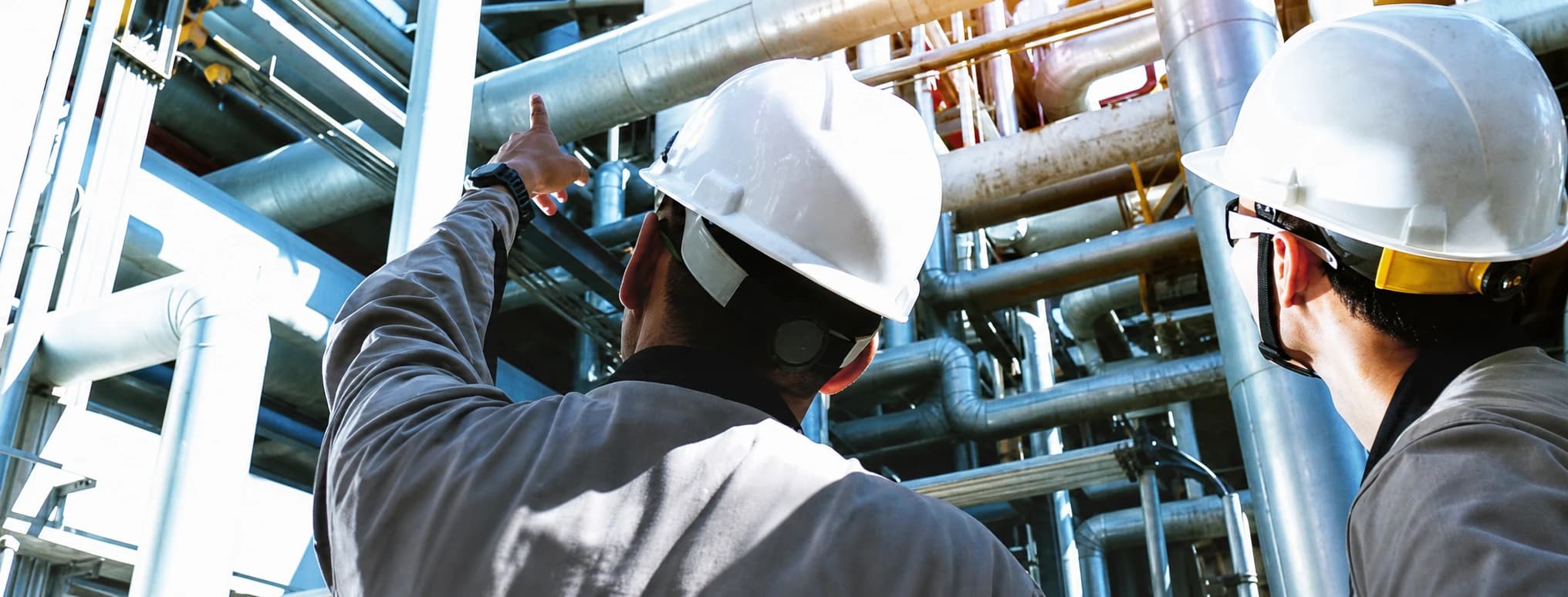 Two Hitachi plant engineers inspecting industrial pipework